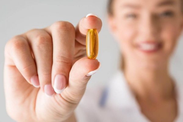 woman-holding-supplement-close-to-camera